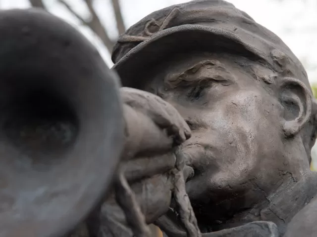 Sculpture detail of a person playing an instrument.