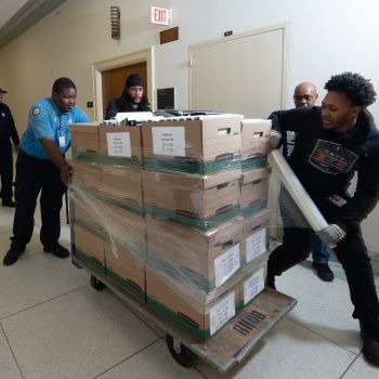 AOC House Office Buildings employees work together to shrink wrap boxes, ensuring a safe move.