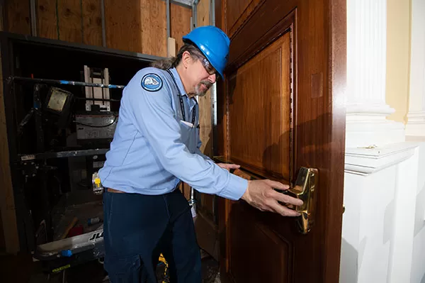 Installing new hardware as the finishing touch on a finished door in the Thomas Jefferson Building.