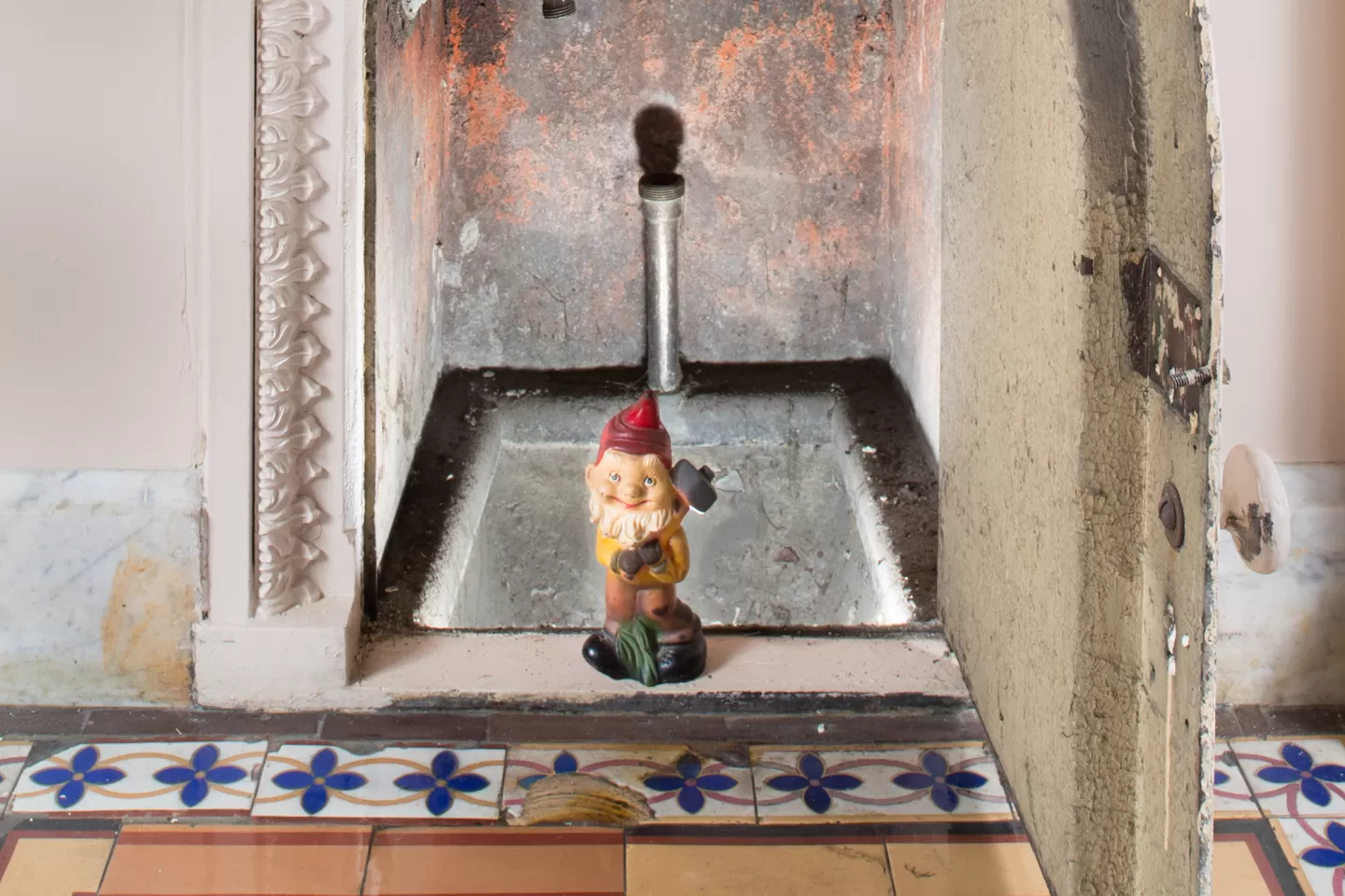 Gnome statue in tiny doorway.