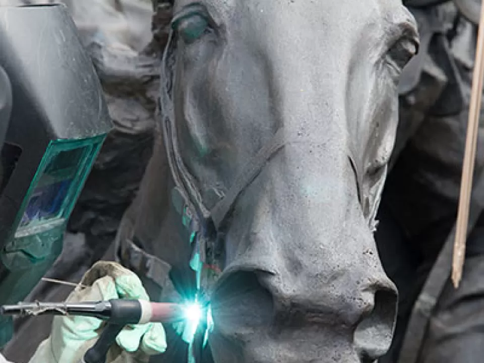 Welding of bronze work to a horse sculpture at the Grant Memorial during restoration in 2016.